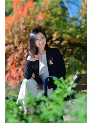 Avery Quan 坐在公园长椅上，周围是秋叶